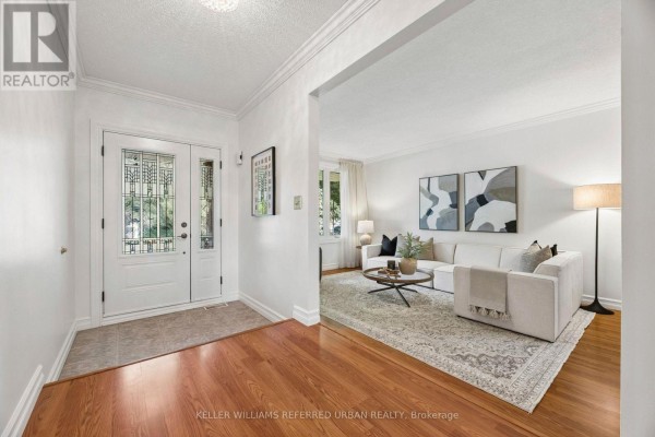 Interior entryway with white double doors, hardwood floors, and a view into the living room. - 72 Munro Crescent, Uxbridge