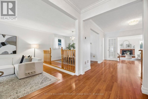 Interior view from the living room towards the entryway, dining area, and a separate family room. - 72 Munro Crescent, Uxbridge