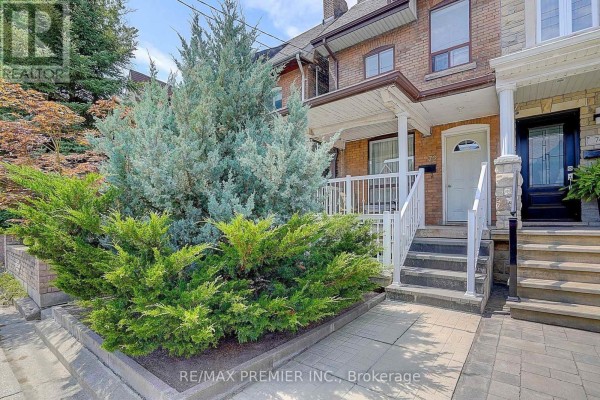 Side view of the house entrance with brickwork, stone columns, and white railings on the porch. - 72 Symington Avenue, Toronto