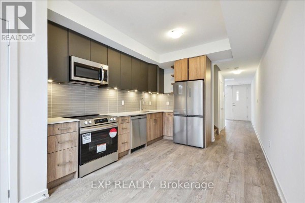 Modern kitchen with stainless steel appliances, grey backsplash, and light wood cabinetry. - 72 Turtle Island Road, Toronto