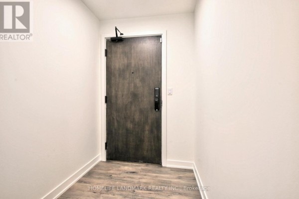 Apartment entrance hallway with a dark wood door, smart lock, and light grey wood-look flooring. - 720 - 1005 Dundas Street E, Oakville