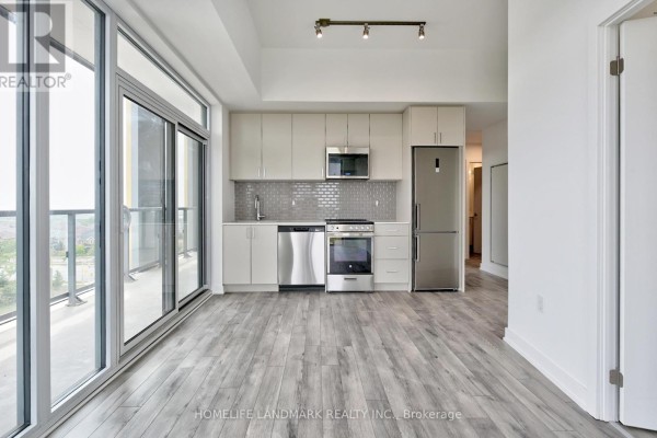Open-concept kitchen with light grey cabinets, stainless steel appliances, and grey tile backsplash. - 720 - 1005 Dundas Street E, Oakville