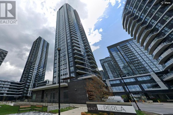 Modern kitchen with white cabinets, stainless steel appliances, and an island overlooking a living area. - 720 - 35 Watergarden Drive, Mississauga