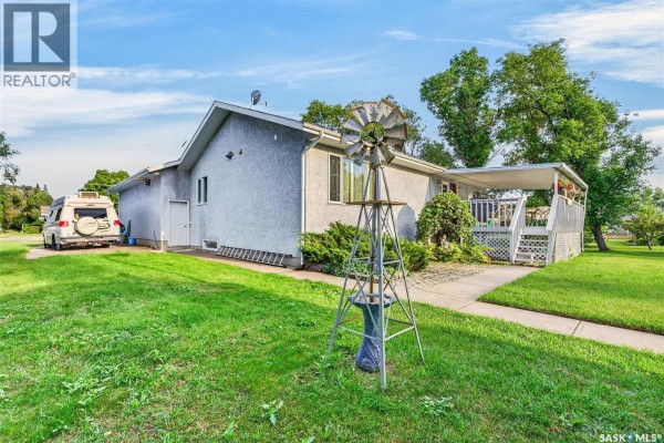 Aerial view of a residential house with a grey roof, driveway, and landscaped yard. - 720 6th Avenue, Rosthern