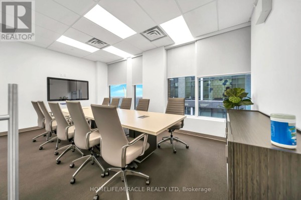 Boardroom with a large conference table, chairs, a screen, and window views. - 721 - 130 Queens Quay E, Toronto