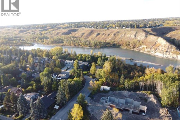 Aerial view of the neighborhood showing houses, trees, and the Bow River valley. - 7219 Bow Crescent Nw, Calgary