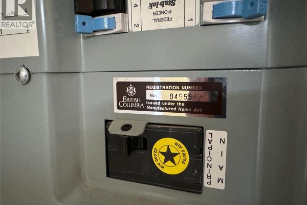 Close-up of a grey electrical panel with a British Columbia registration number sticker for a manufactured home. - 7225 Boundary Drive Unit# 7, Grand Forks
