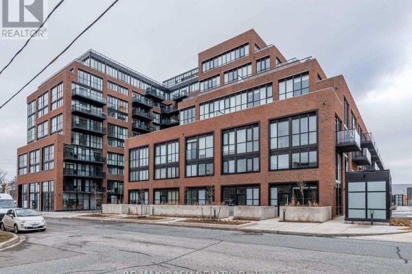 Exterior view of a brick apartment building with balconies and large windows. - 723 - 2300 St Clair Avenue W, Toronto