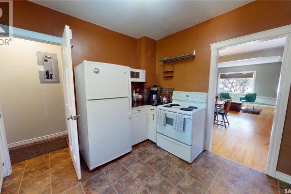 View of the kitchen from the doorway, showing appliances and an opening to a dining area. - 723 9th Street E, Saskatoon