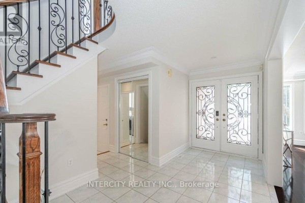Interior foyer with tiled flooring, a grand staircase with ornate railing, and double front doors. - 724 Peter Robertson Boulevard, Brampton