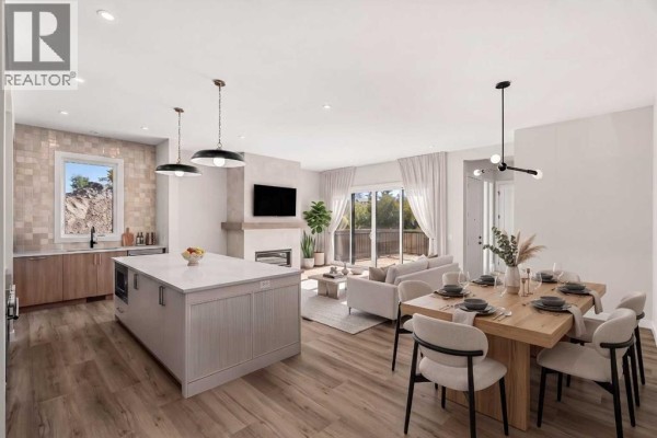 Open concept living area with kitchen island, dining table, fireplace, and patio doors. - 725 53 Avenue Sw, Calgary
