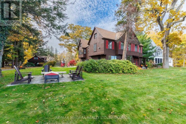 Backyard with a stone patio, lawn chairs, and trees, showcasing autumn foliage. - 725 Point Abino Road S, Fort Erie