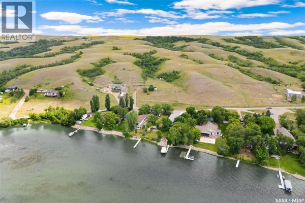 Expansive view of rolling hills with a greenhouse and some scattered buildings. - 726 Daniel Drive, Buffalo Pound Lake