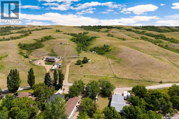 Overhead view of a winding road leading to a lake with several docks and boats. - 726 Daniel Drive, Buffalo Pound Lake