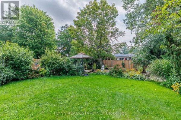 Green backyard with gazebo, trees, bushes, and flowers - 7260 Mccoll Drive Niagara Falls