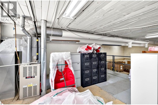 Utility area with furnace, metal filing cabinets, and industrial piping. - 728 Tagish Street, Kamloops