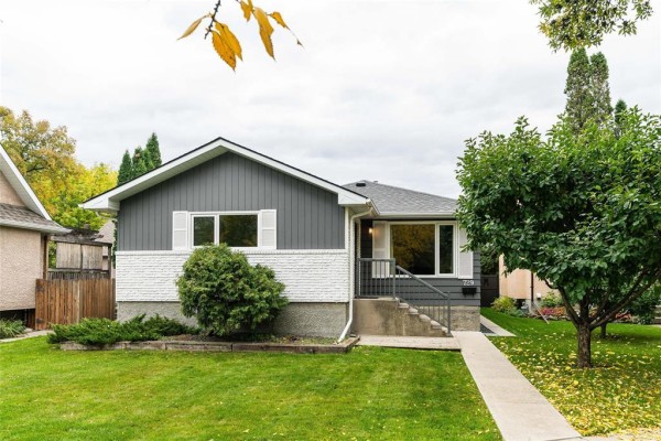 Front of a grey and white bungalow with white shutters and a concrete walkway. - 729 Kildonan Drive, Winnipeg