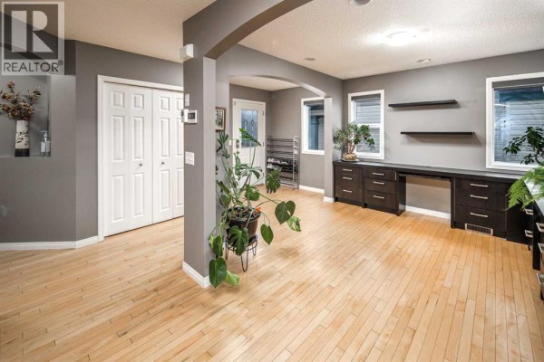 Hallway with a doorway to the office, a closed closet, and a plant. - 73 Evansbrooke Way Nw, Calgary