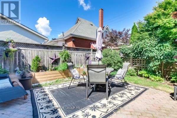 Outdoor dining area on a brick patio with a table, chairs, and rug. - 73 Fifth Avenue, St  Thomas