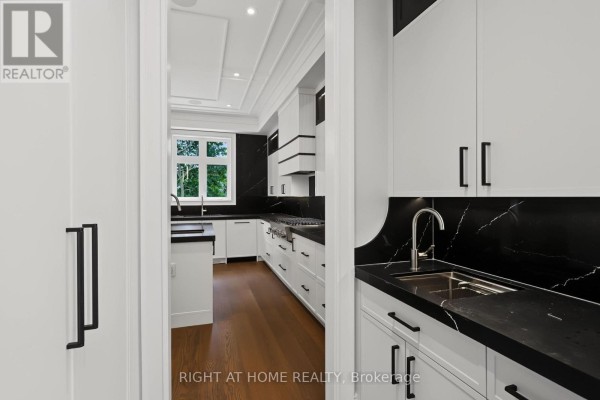 Modern kitchen with white cabinets, black marble counters, stainless steel sink & gas range - 73 Harding Boulevard Richmond Hill