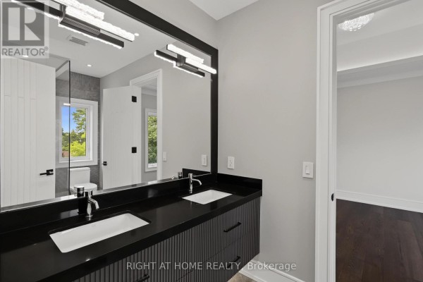 Modern double vanity bathroom with dual sinks and black countertop - 73 Harding Boulevard Richmond Hill