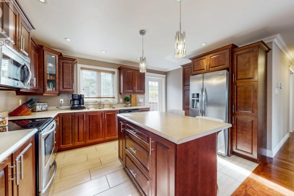 Kitchen with stainless steel appliances, wood cabinets, and a large island. - 73 Sgt. Donald Lucas Drive, Paradise