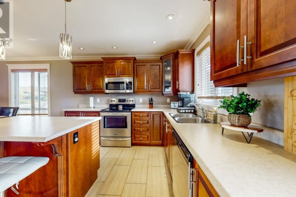 Kitchen with light countertops, stainless steel appliances, and wood cabinetry. - 73 Sgt. Donald Lucas Drive, Paradise