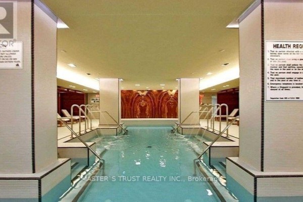 Indoor swimming pool with tiled walls, decorative art, and lounge chairs. - 731 - 39 Queens Quay E, Toronto
