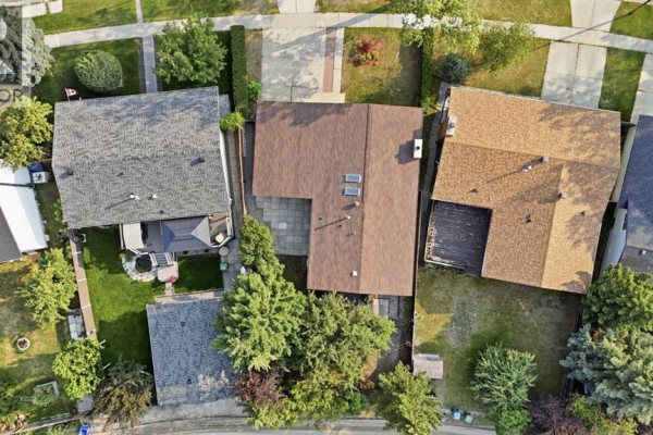 Aerial view of the property at 731 Queensland Drive SE, Calgary, showcasing the roof and backyard. - 731 Queensland Drive Se, Calgary