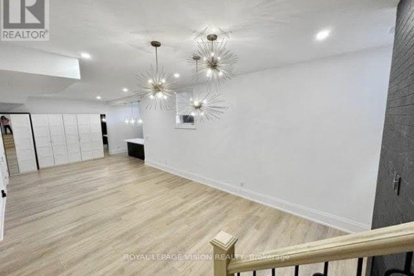 An open-concept living area with light wood floors, white walls, and storage closets on the left. - 732 West Shore Boulevard, Pickering