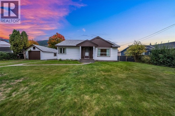 Exterior view of the house from the side, showing the driveway and garage. - 735 10th Avenue, Montrose
