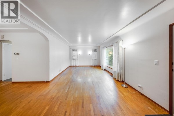 Wide angle view of the empty living room with arched entryway and wood floors. - 735 10th Avenue, Montrose