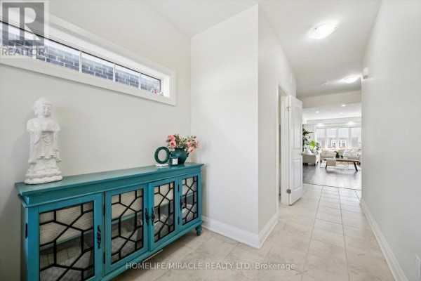 Open concept living, dining, and kitchen area with dark wood floors, white cabinets, and modern furniture. - 736 Wood Lily Street, Waterloo