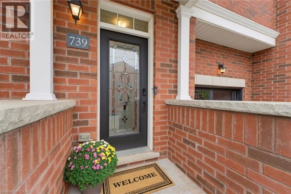 Close-up of front door at 739 Banks Crescent with decorative glass and brick exterior. - 739 Banks Crescent, Milton