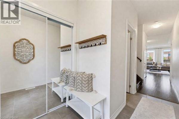 Interior view of entryway with mirrored closet, benches, hallway leading to living area. - 739 Banks Crescent, Milton