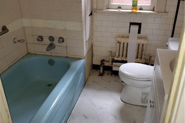 Small bathroom with a light blue bathtub, white toilet, and a white vanity. - 74 Carrick Avenue, Hamilton