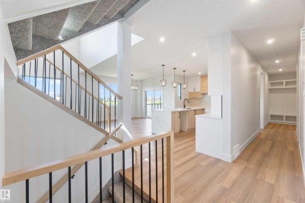 Interior view of a foyer and hallway leading to an open-concept kitchen and living area. - 74 Eldridge Pt, St  Albert