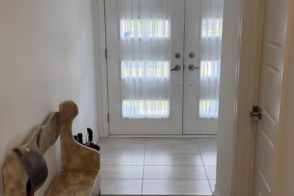 Interior entryway of a townhouse with white double doors featuring sheer curtains and tile flooring. - 74 Forestwalk Street, Kitchener