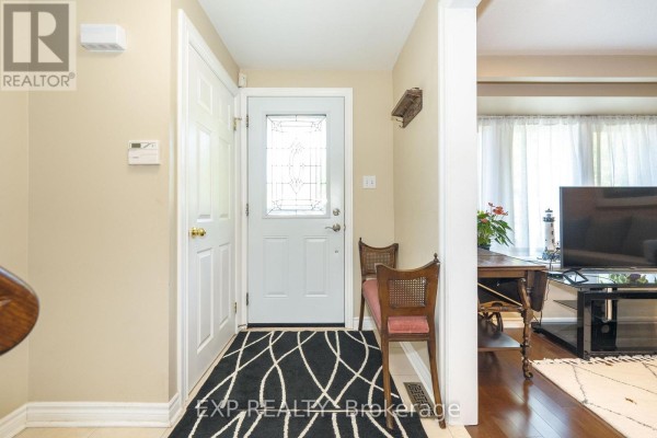 Interior entryway with beige walls, white doors, bench, and patterned rug. - 74 Longford Crescent, Toronto