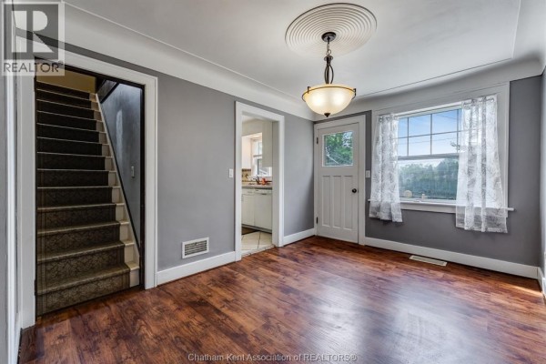 Dining area with grey walls, dark wood floors, and a staircase leading upstairs. - 74 Marlborough Street East, Leamington
