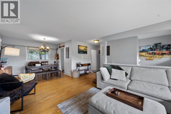 Open concept living and dining area with hardwood floors and large windows. - 740 Sherwood Drive, Kamloops