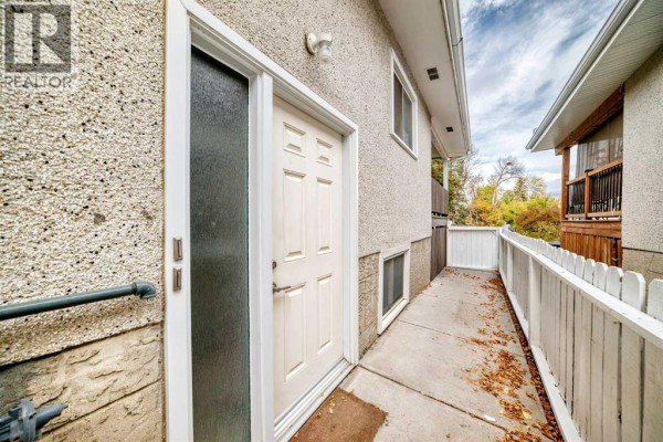 Side exterior view of a duplex showing the entrance door and walkway. - 7409 37 Avenue Nw, Calgary