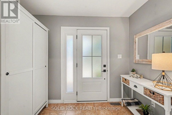 Interior view of a home entryway with a white closet, frosted glass door, and console table. - 742 Merkley Drive, Ottawa