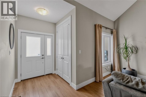Master bedroom with large windows, neutral decor, and wooden flooring. - 744 Nelson Street Unit# 5, Port Dover