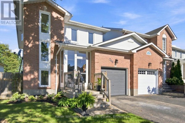 Side view of a two-story brick and vinyl townhouse with two garage doors. - 746 Elderberry Drive, Oshawa