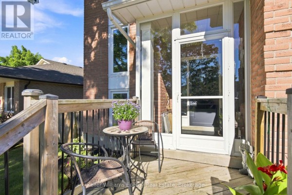 Small wooden deck with a table and two chairs in front of a screened-in porch. - 746 Elderberry Drive, Oshawa