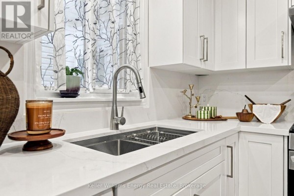 Close-up of a double stainless steel sink and white quartz countertops in a kitchen. - 746 Elderberry Drive, Oshawa