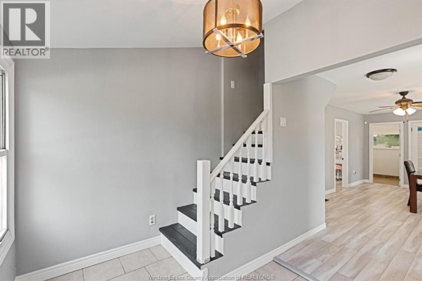 Interior staircase with grey walls, white railings, and dark treads. - 748 Scratch Lane, Kingsville