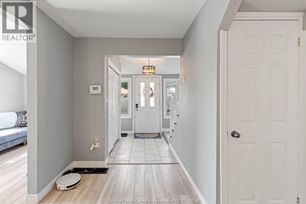 Hallway with light wood flooring, grey walls, and a white front door. - 748 Scratch Lane, Kingsville