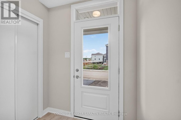Kitchen island with granite countertop and double sink facing a large window and glass door. - 749 Haflinger Row, Ottawa